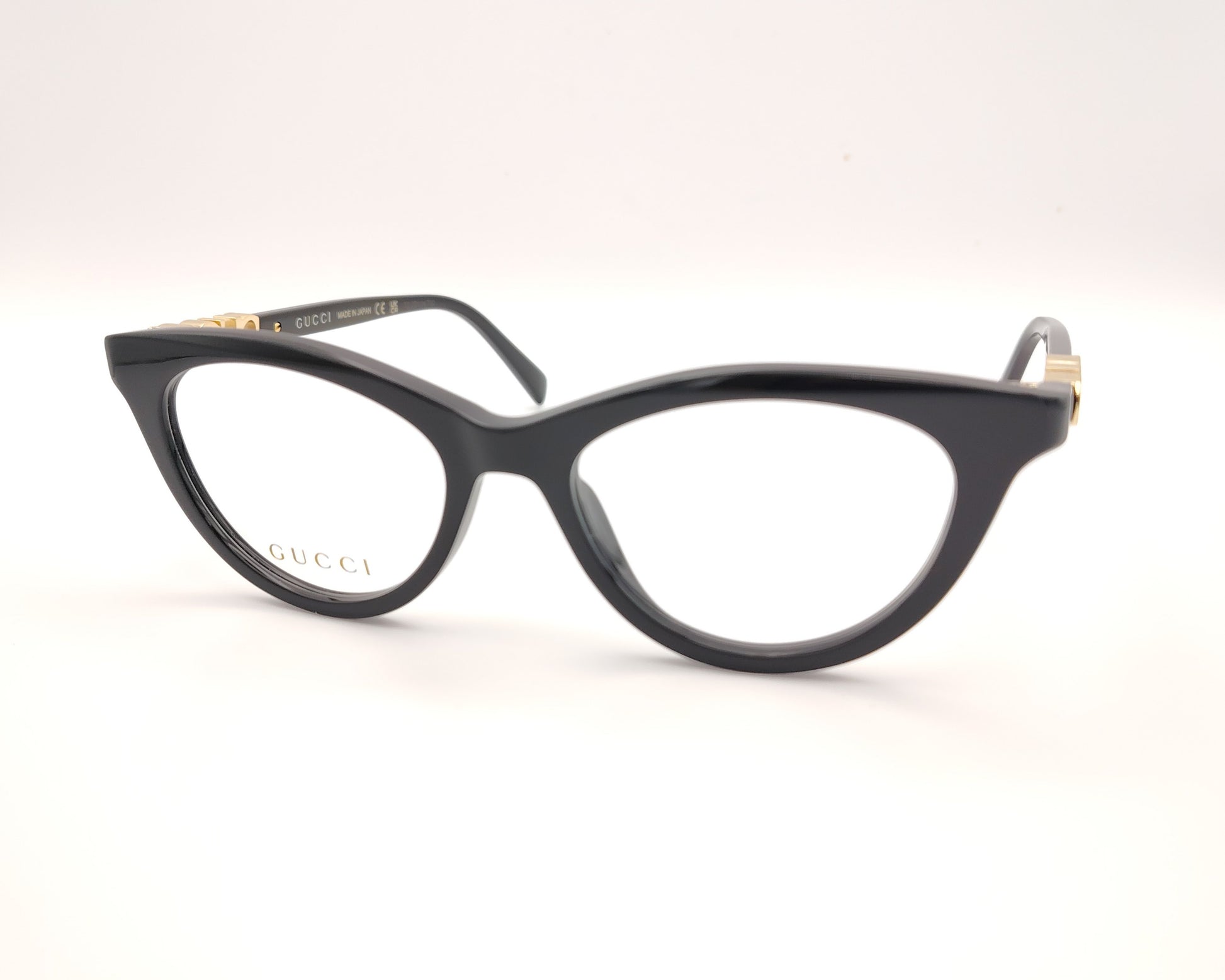gafas gucci negras redondeadas con logo dorado en varilla