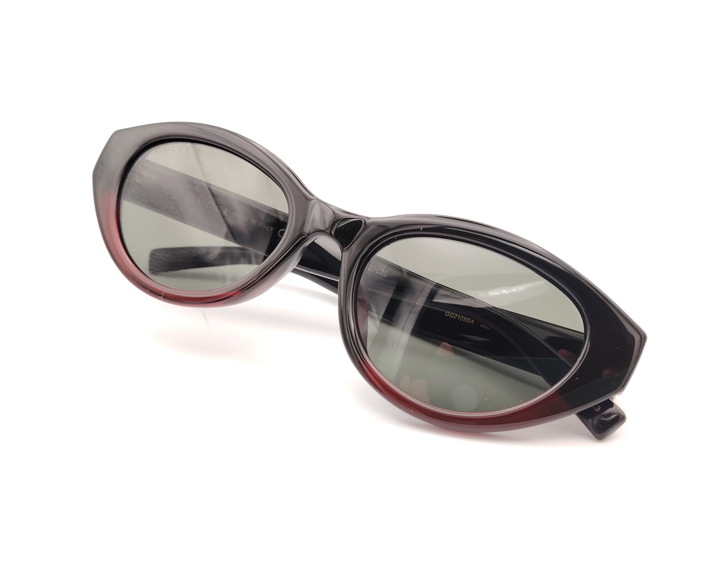 gafas de sol gucci ovaladas negras con detalle burdeos y varillas con logo dorado y bandas verde y roja