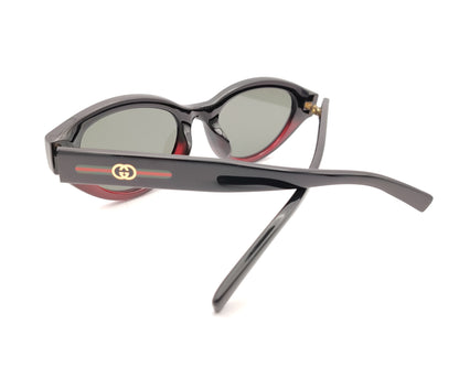 gafas de sol gucci ovaladas negras con detalle burdeos y varillas con logo dorado y bandas verde y roja