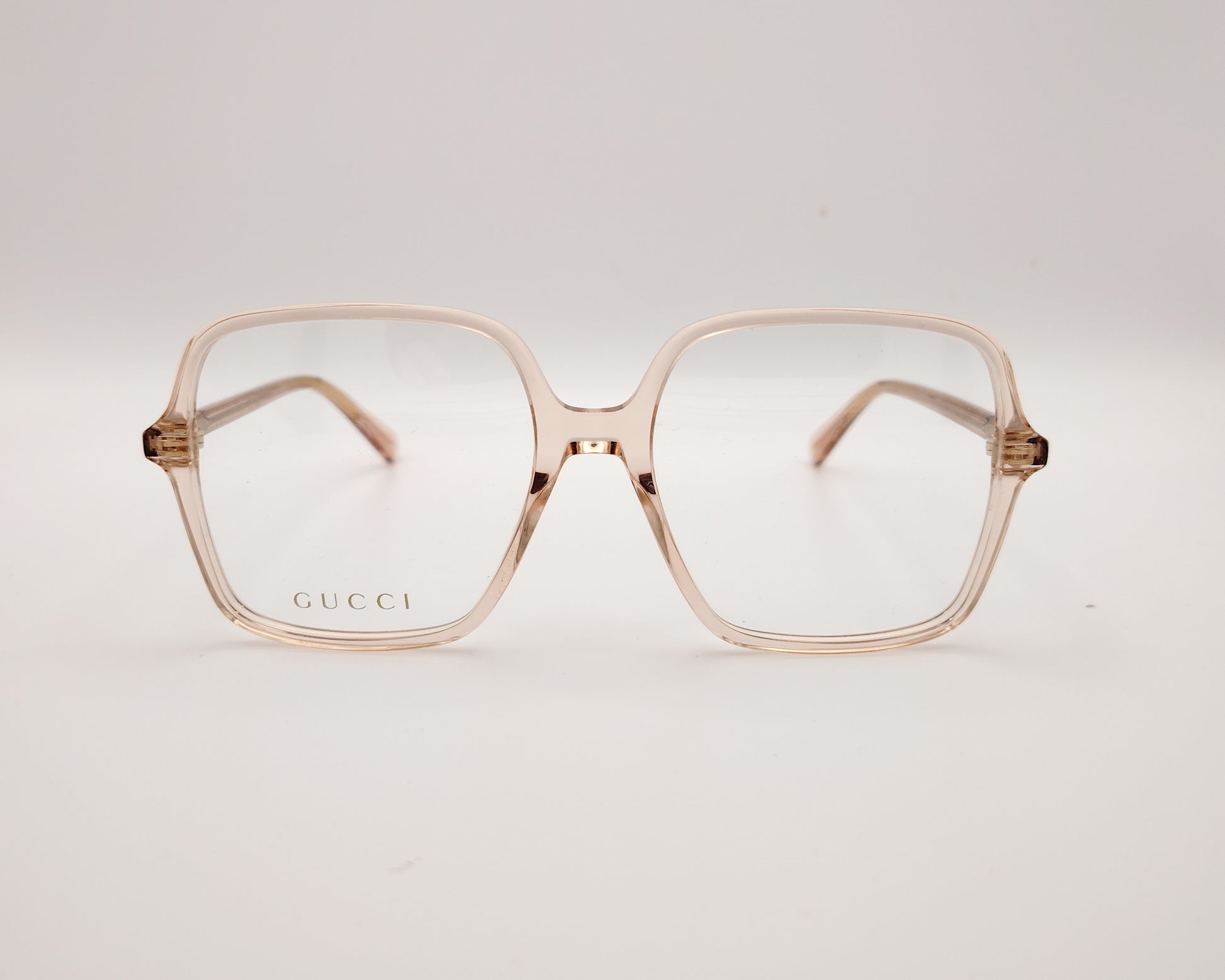 gafas graduadas de oversize con montura cuadrada en tono rosa claro translúcido y logotipo gucci en la lente izquierda
