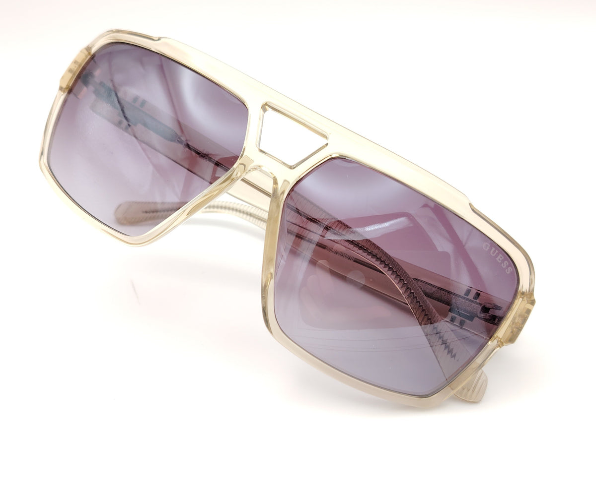 gafas de sol guess con montura champán translúcida y lentes púrpura degradadas en diseño oversize