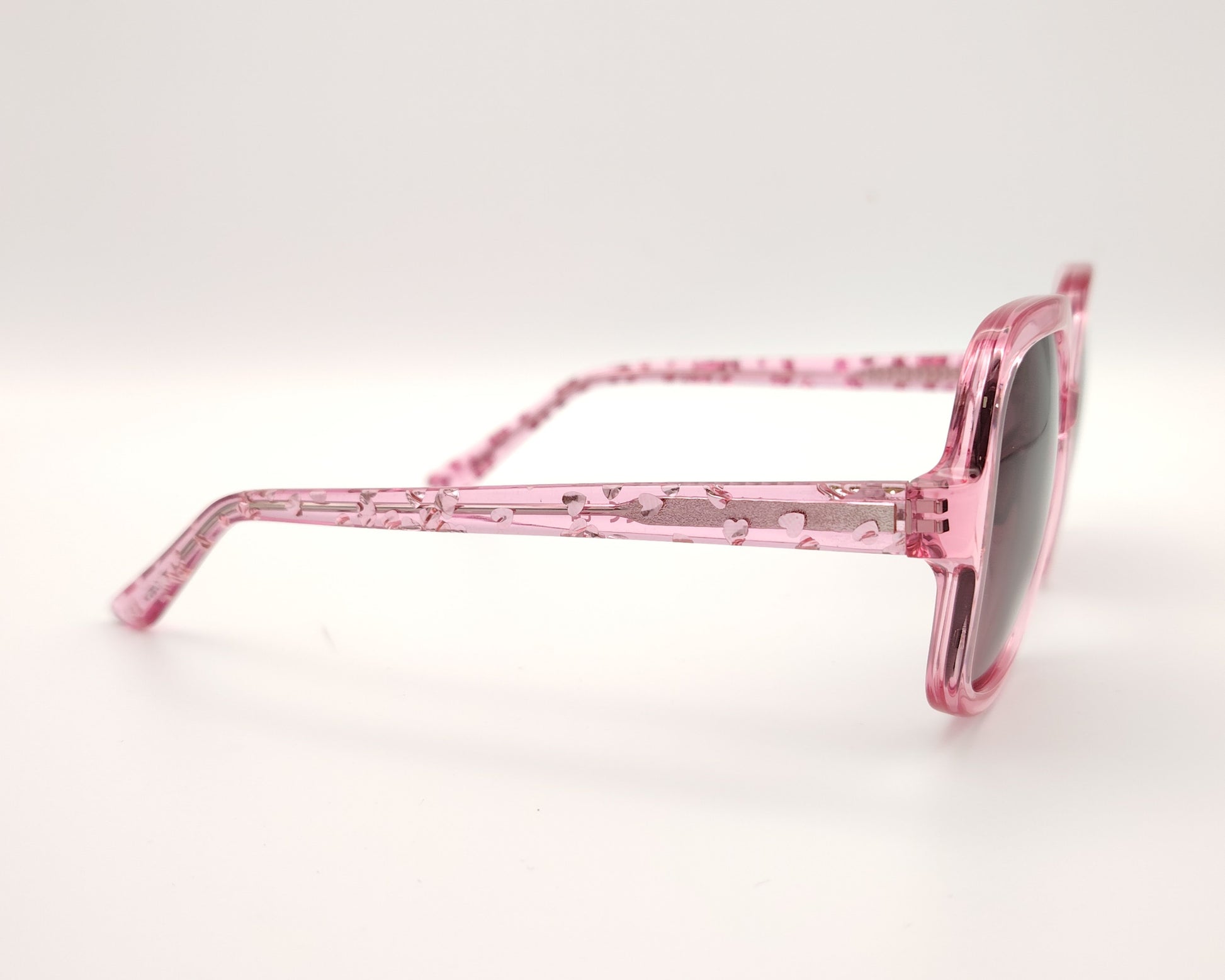 gafas de sol guess rosas translúcidas con lentes malva degradadas y corazones en la varilla