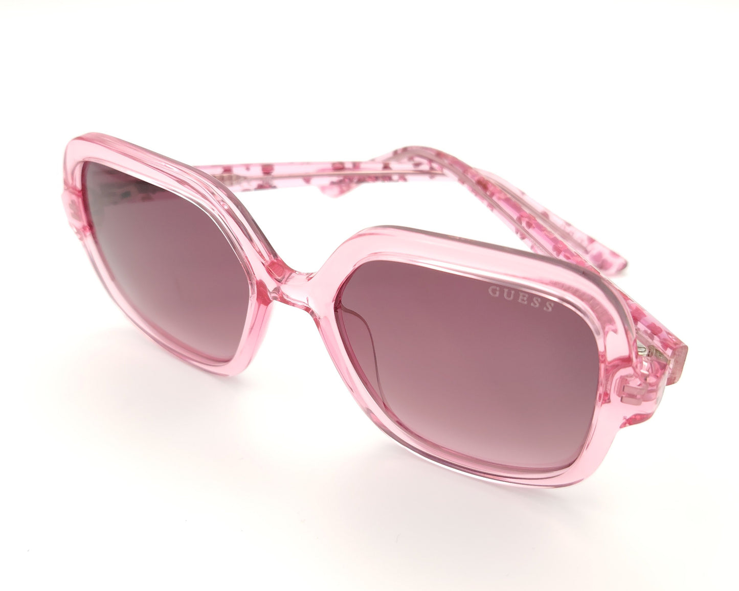 gafas de sol guess rosas translúcidas con lentes malva degradadas y corazones en la varilla