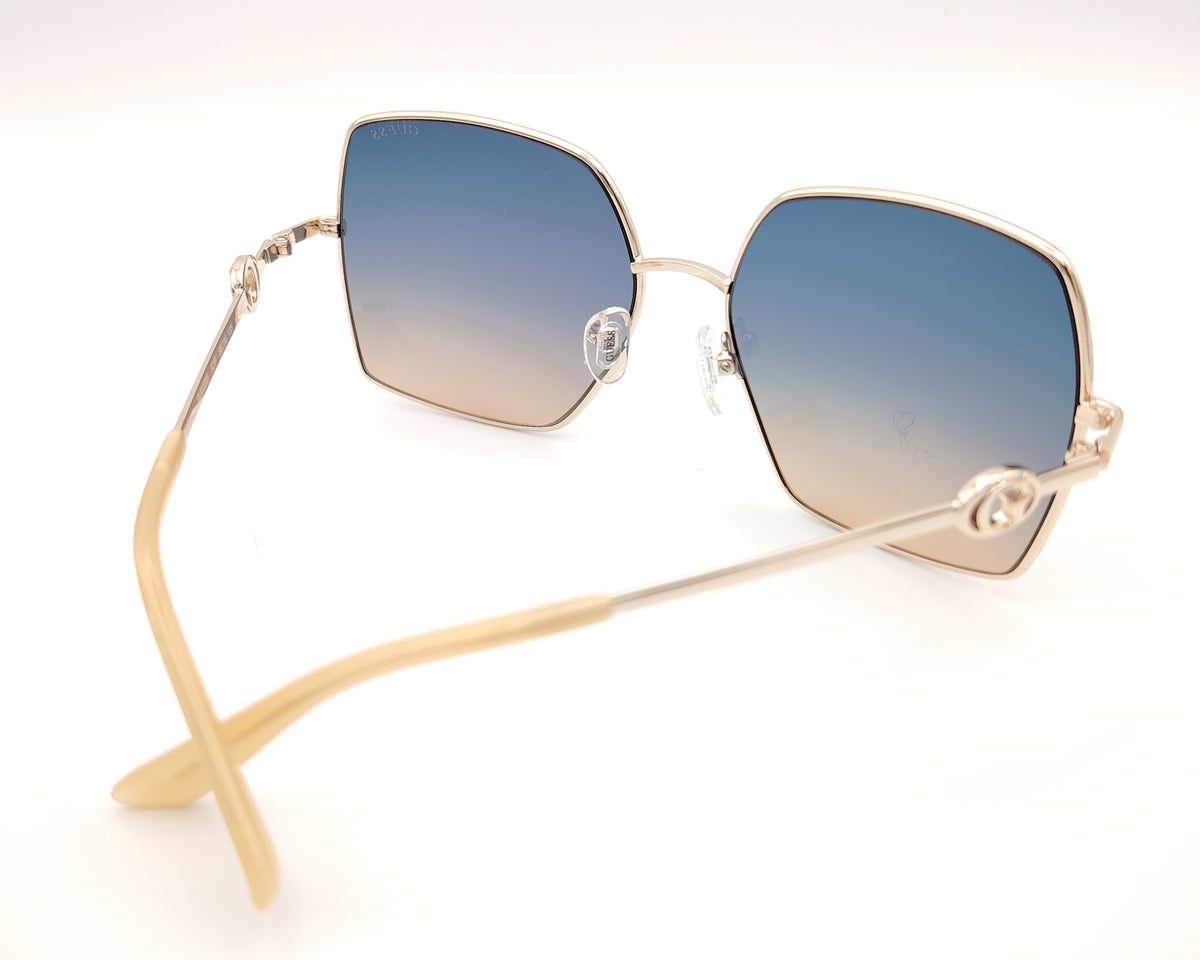 gafas guess cuadradas con montura dorada fina y lentes degradadas azul y marrón