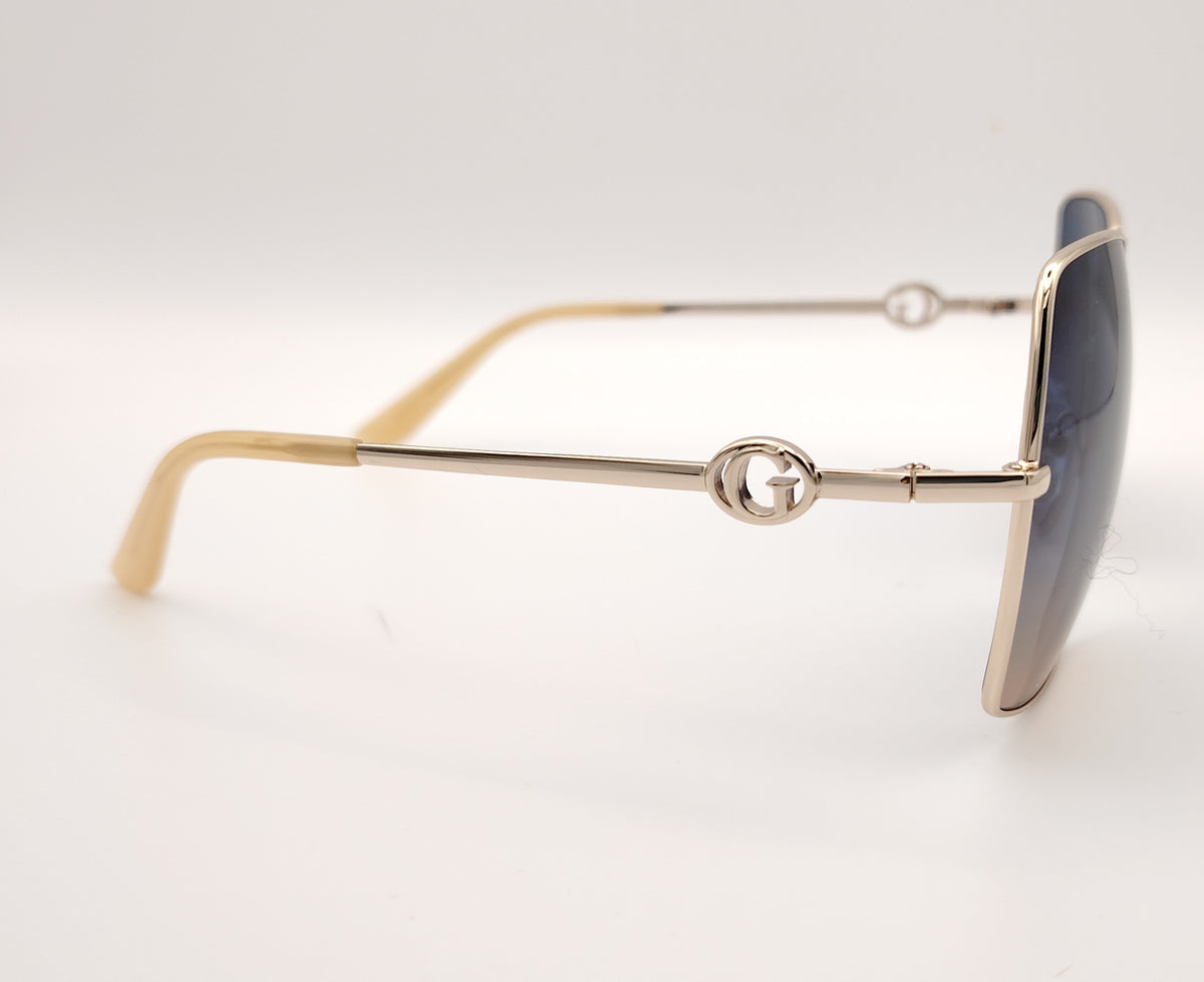 gafas guess cuadradas con montura dorada fina y lentes degradadas azul y marrón