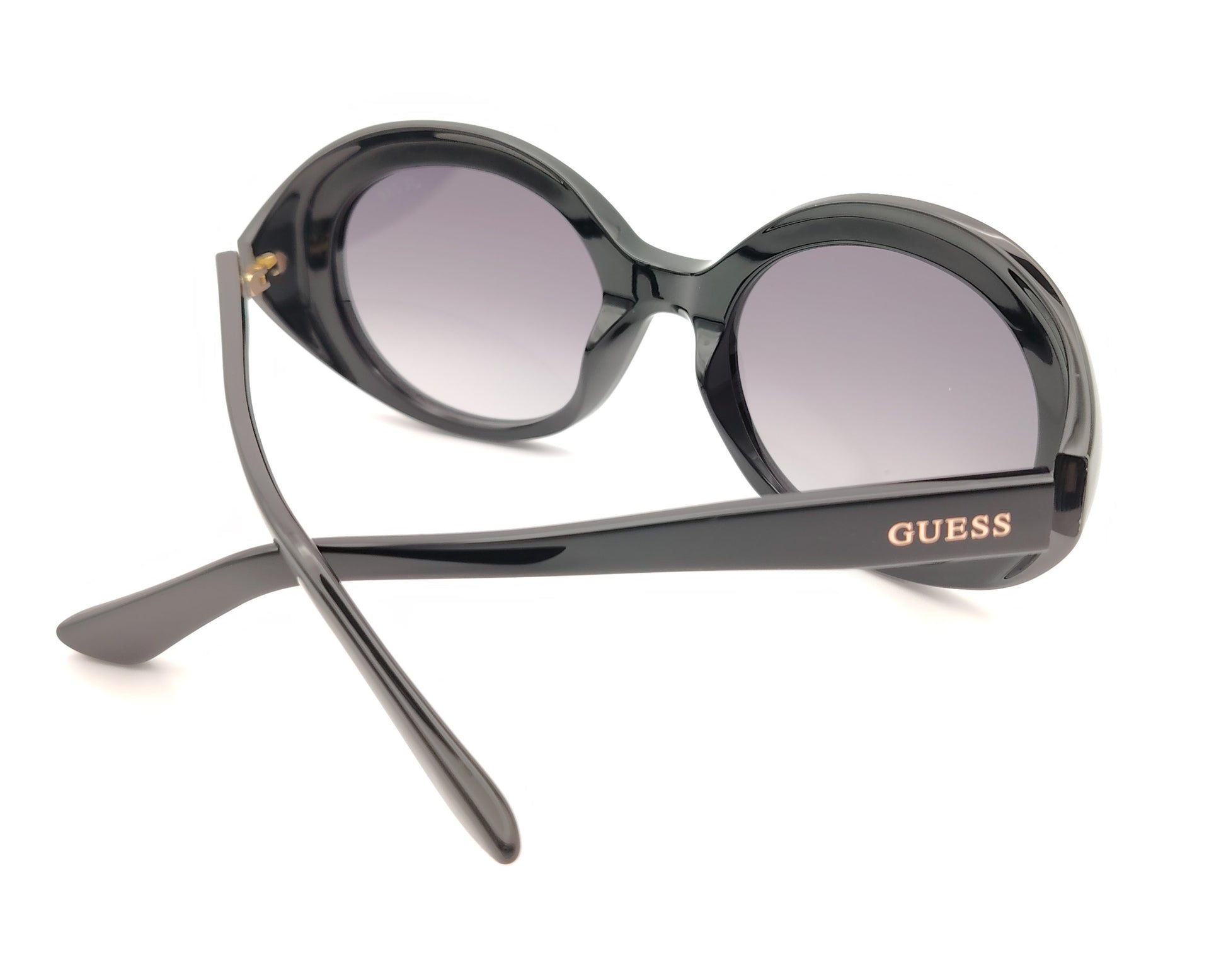 gafas guess negras ovaladas con lentes gris violáceo degradadas y logo dorado en la patilla