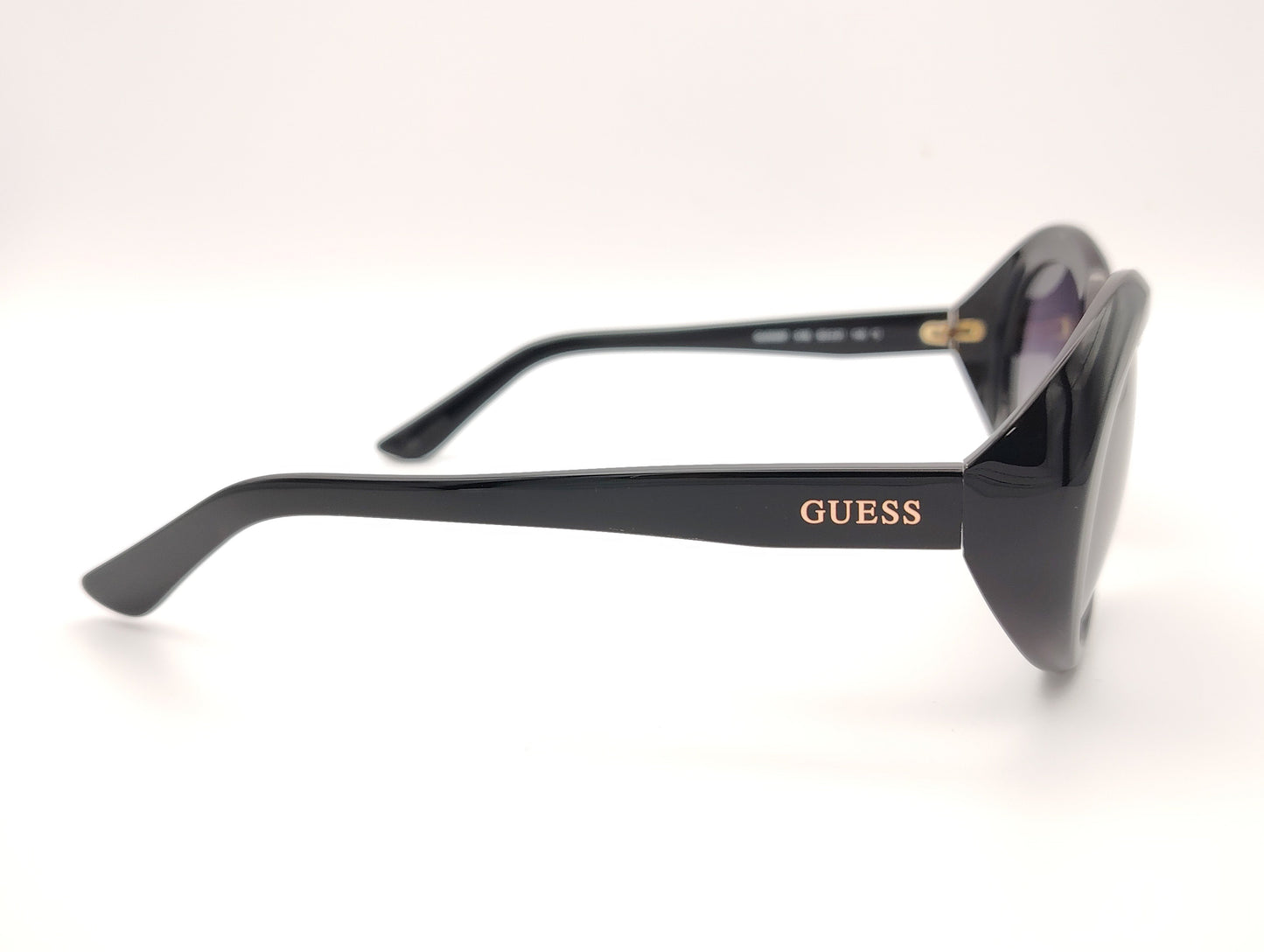 gafas guess negras ovaladas con lentes gris violáceo degradadas y logo dorado en la patilla