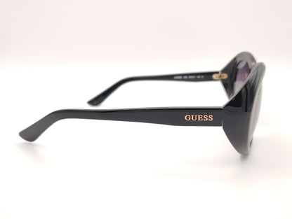 gafas guess negras ovaladas con lentes gris violáceo degradadas y logo dorado en la patilla