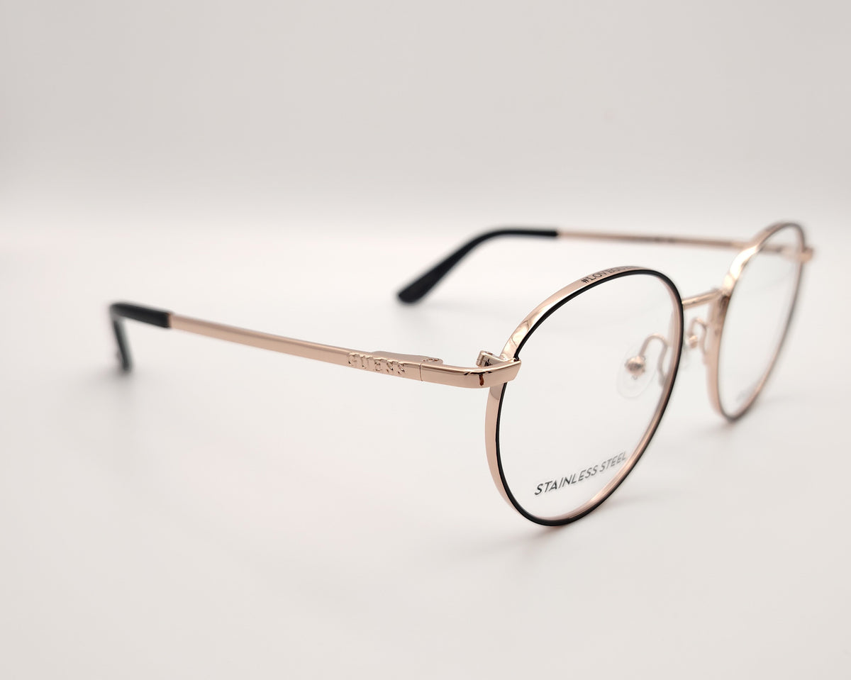 gafas de vista guess con montura redonda de metal dorado con el perfil de los aros en negro