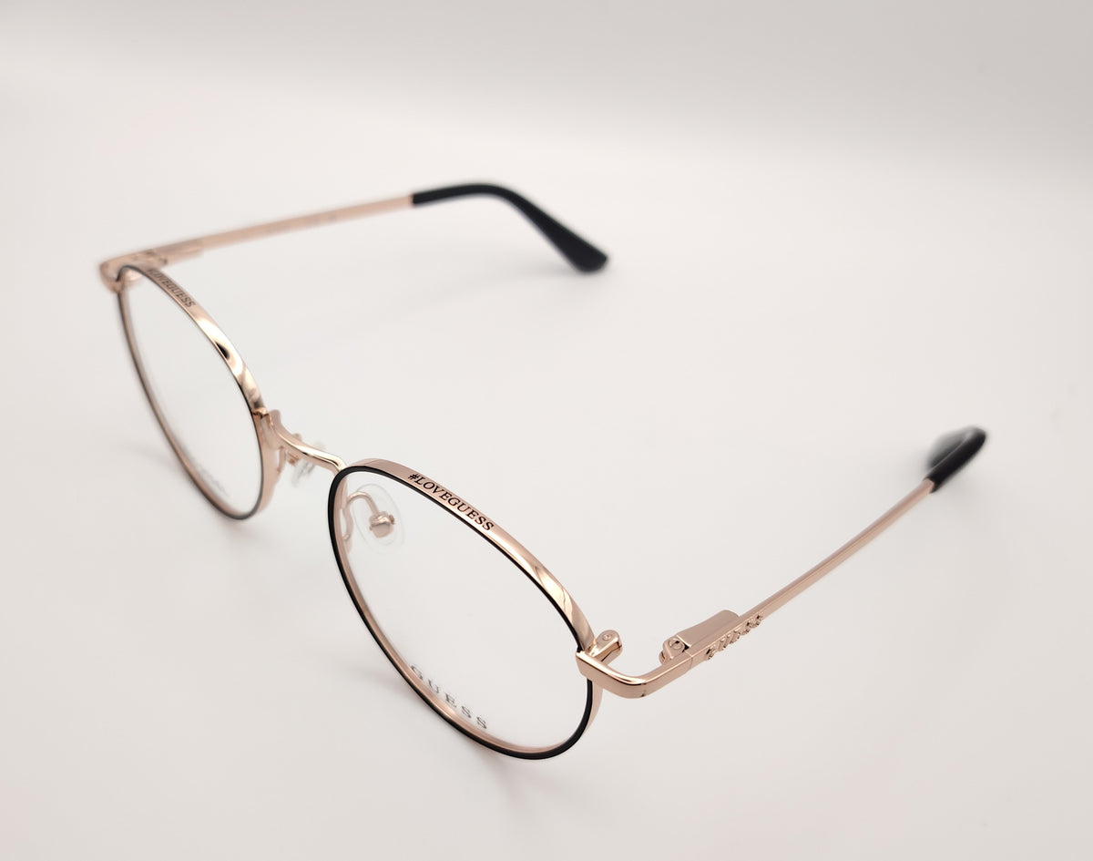 gafas de vista guess con montura redonda de metal dorado con el perfil de los aros en negro