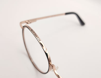 gafas de vista guess con montura redonda de metal dorado con el perfil de los aros en negro