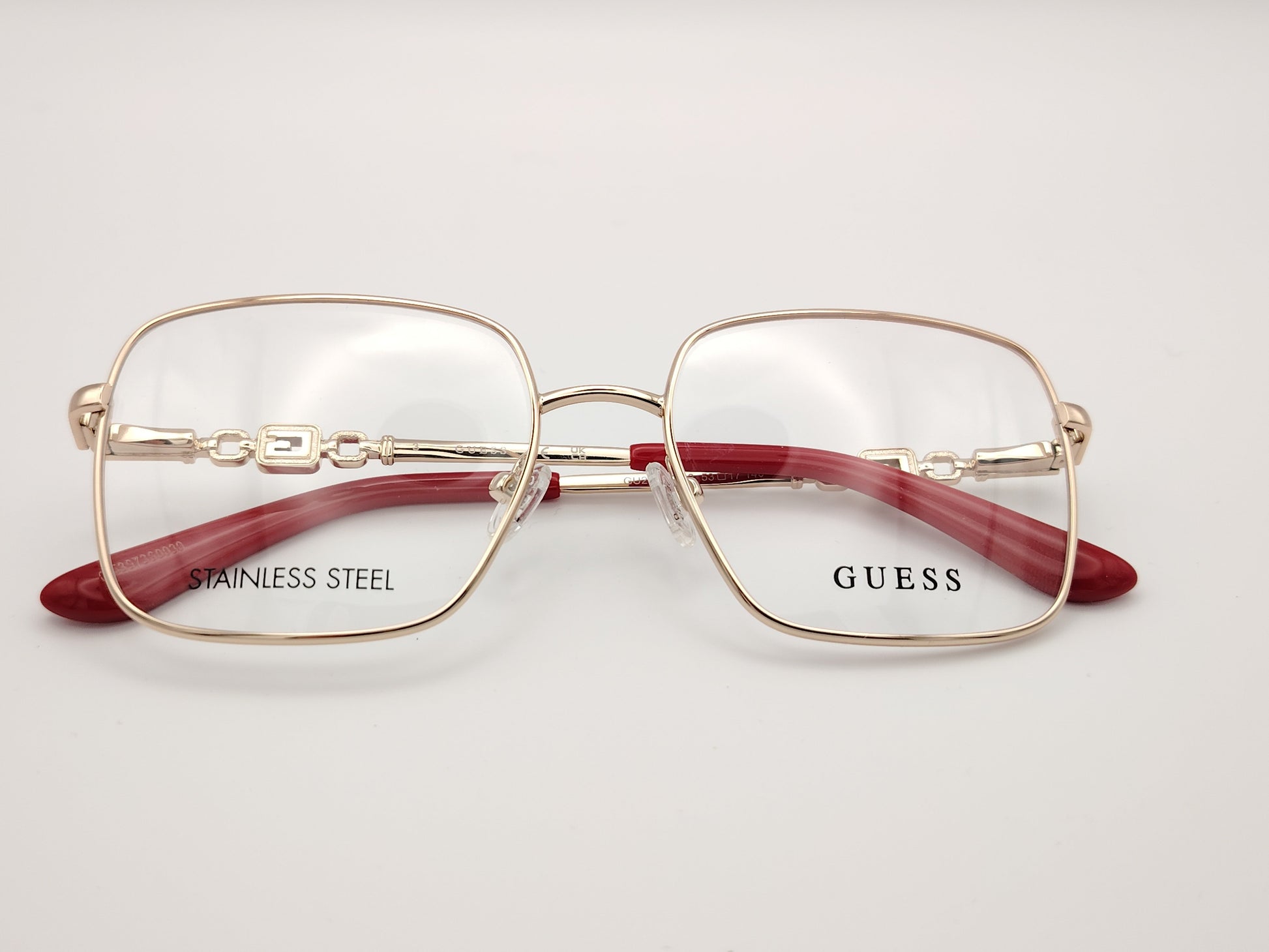 gafas graduadas guess de acero inoxidable doradas con forma cuadrada y terminales rojos