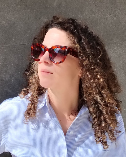 persona con gafas de sol carey de montura gruesa y lentes degradadas