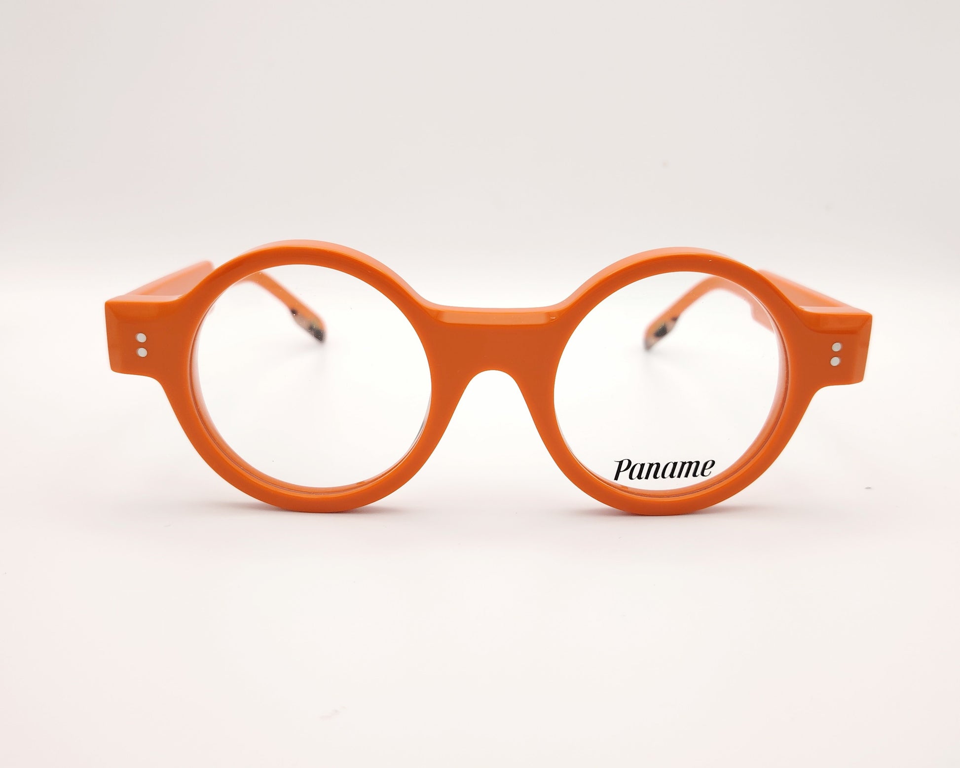 gafas redondas de acetato naranja con detalle dorado en la patilla y frontal grueso