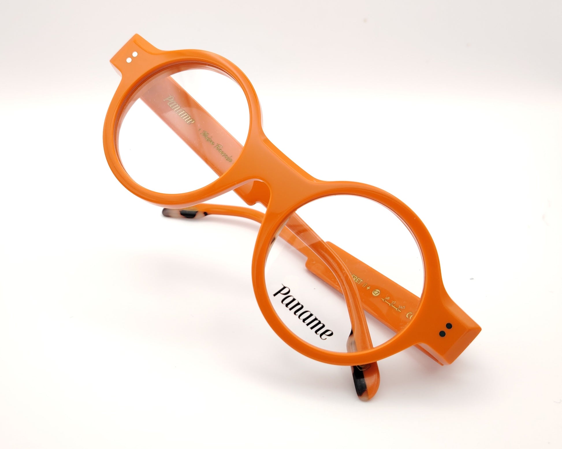 gafas redondas de acetato naranja con detalle dorado en la patilla y frontal grueso