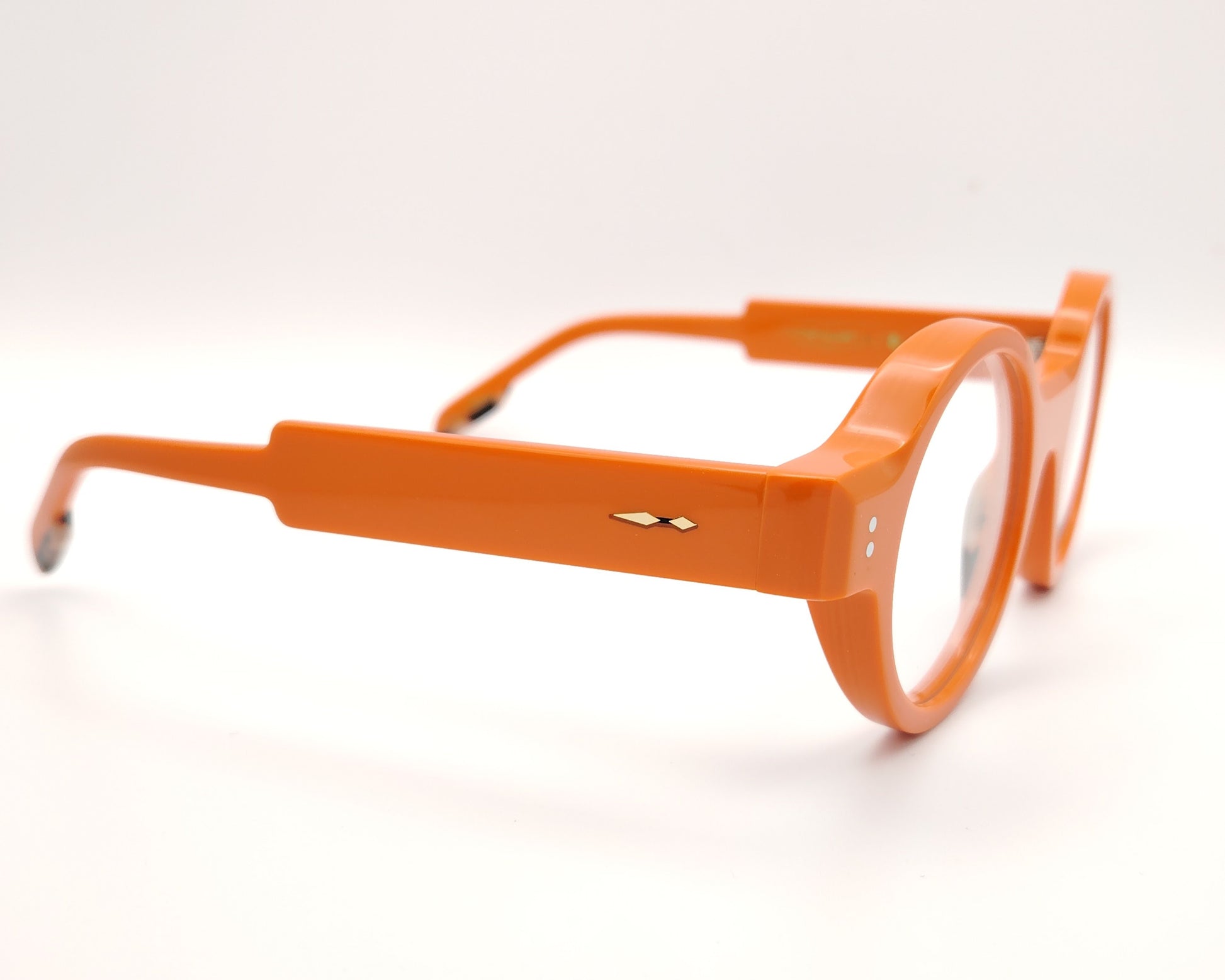 gafas redondas de acetato naranja con detalle dorado en la patilla y frontal grueso