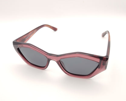 gafas de sol pentagonales con montura rosa translúcida y lentes oscuras polarizadas