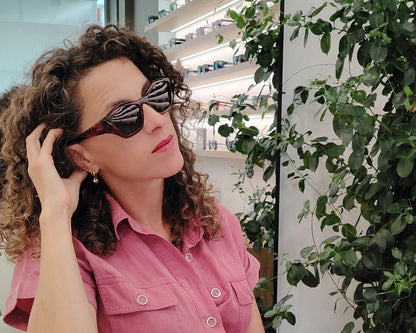 gafas de sol pentagonales con montura rosa translúcida y lentes oscuras polarizadas