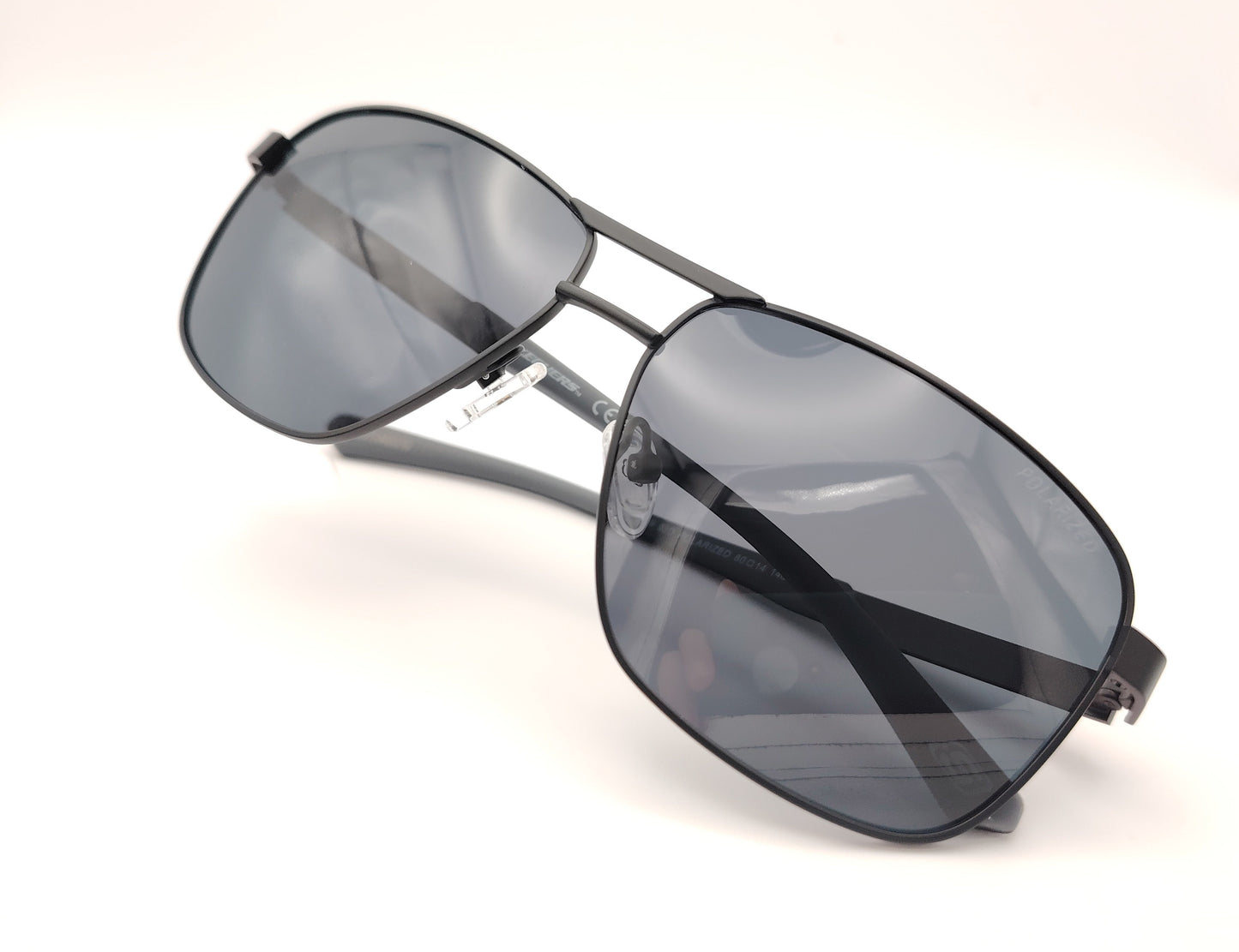 gafas de sol skechers estilo aviador con montura negra y lentes polarizadas oscuras