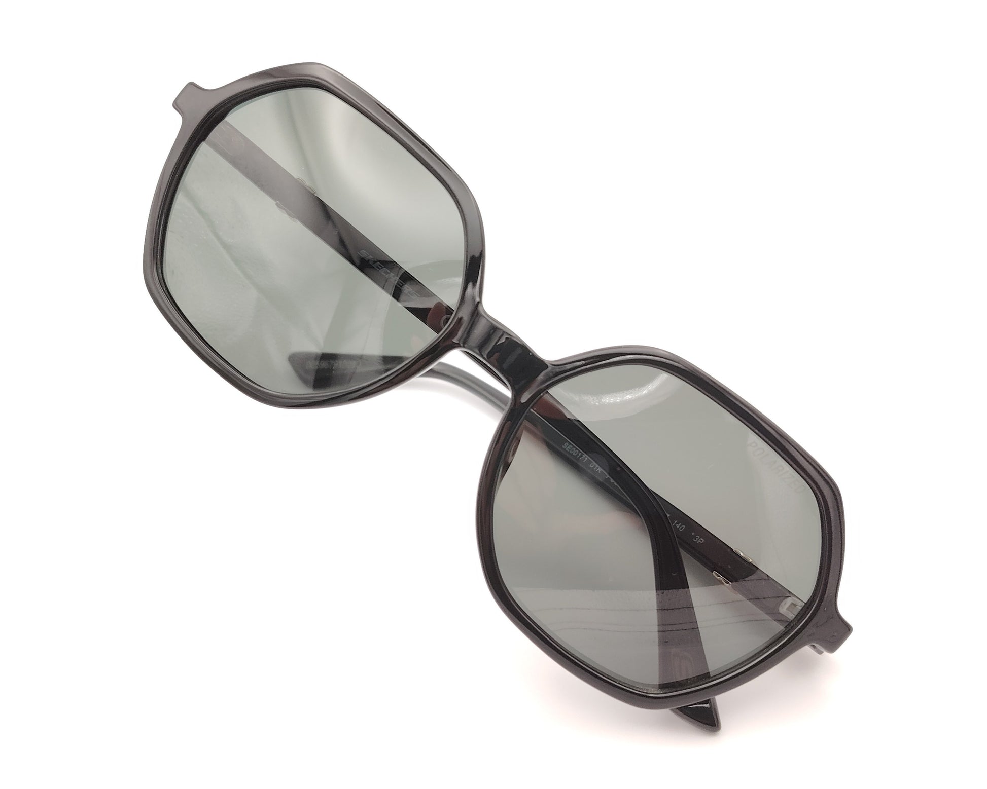 gafas de sol skechers negras con forma geométrica y lentes polarizadas grises