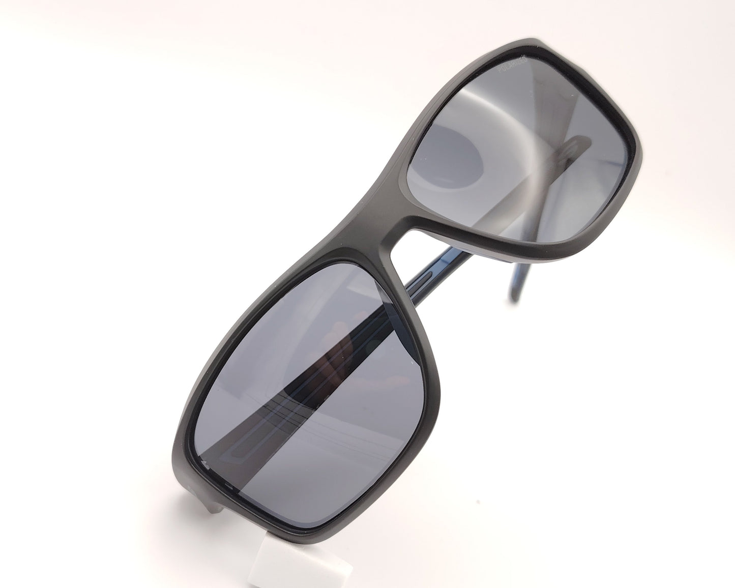gafas de sol skechers envolventes negras con detalles azules y lentes polarizadas oscuras