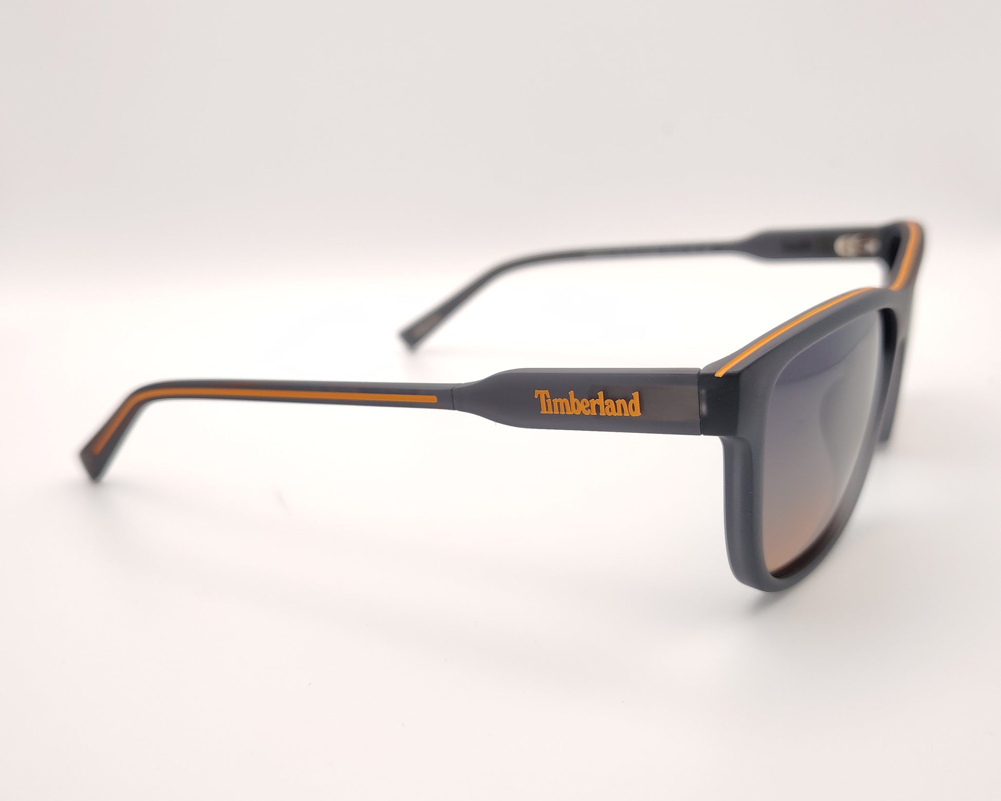 gafas de sol gris mate polarizadas con lentes marron degradado y detalle naranja en varillas