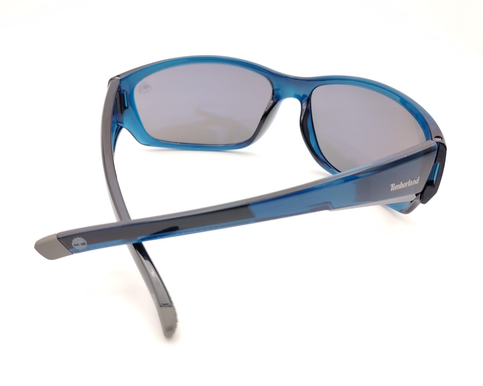 gafas de sol polarizadas azul translúcido con lentes espejo gris y diseño deportivo envolvente