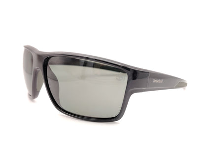 gafas de sol negras polarizadas con lentes gris y diseño deportivo envolvente