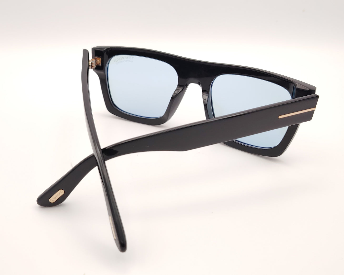 gafas de sol tom ford negras con montura rectangular y lentes fotocromáticas azuladas