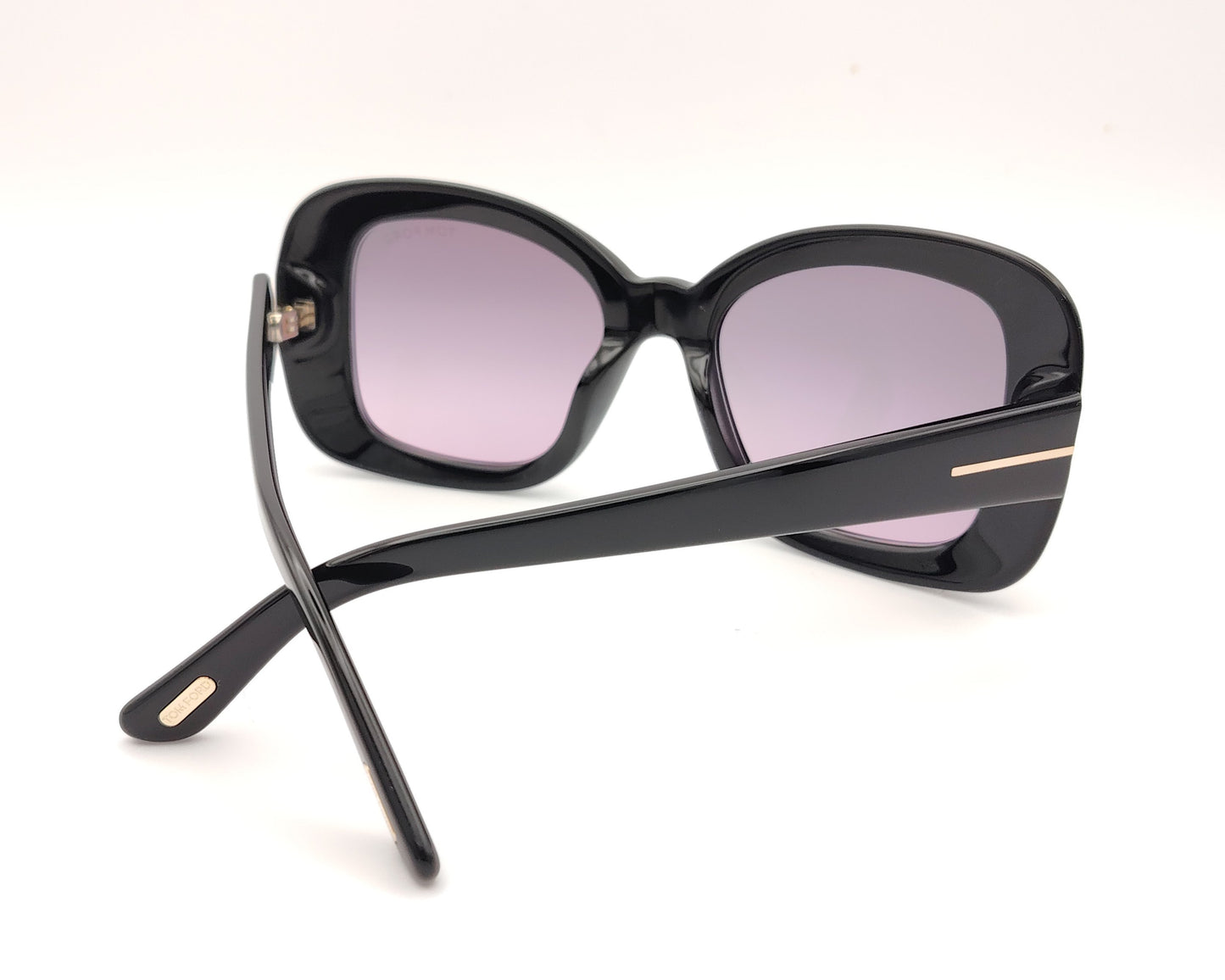 gafas de sol tom ford negras oversize con lentes violetas y detalle metálico en las varillas