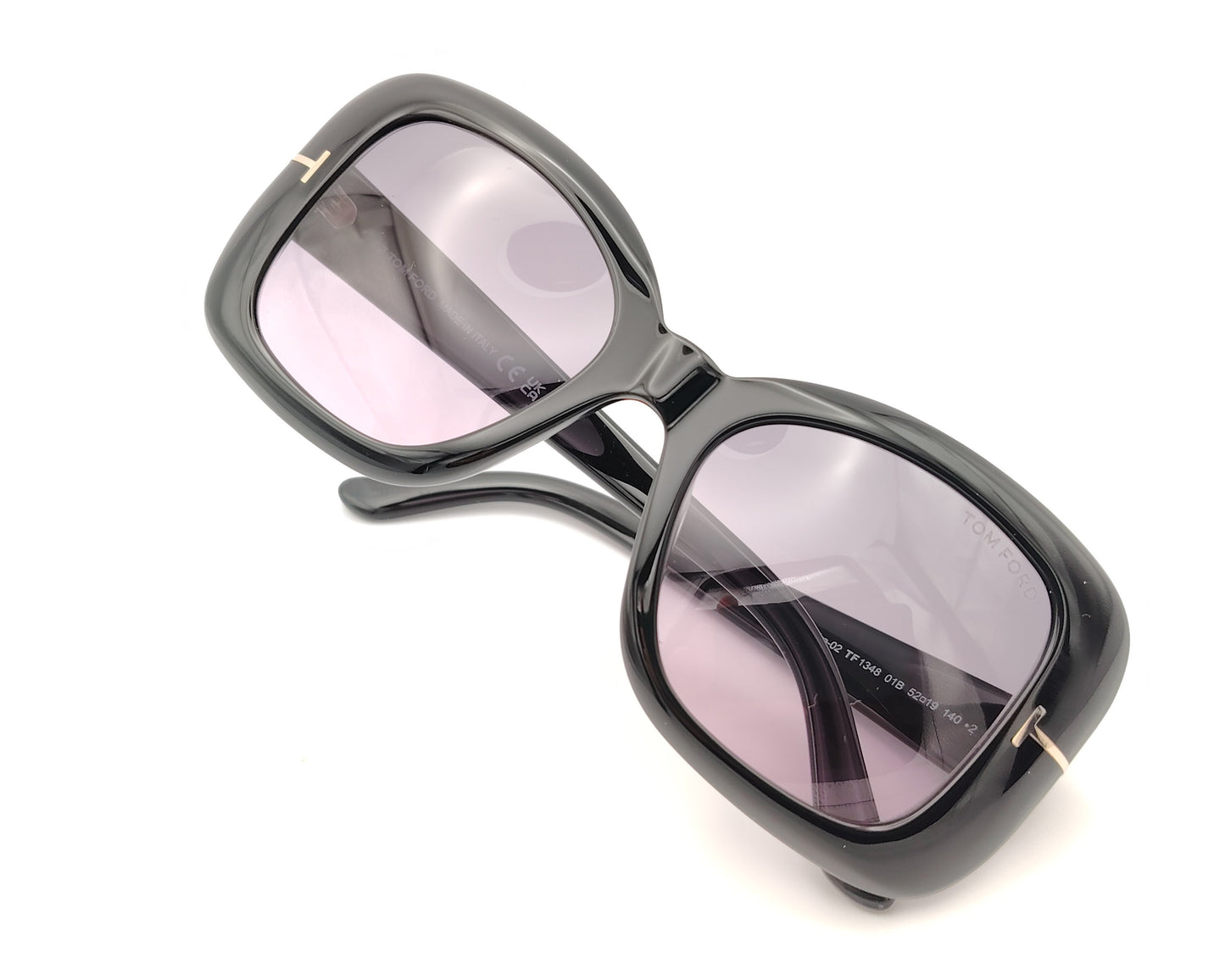 gafas de sol tom ford negras oversize con lentes violetas y detalle metálico en las varillas