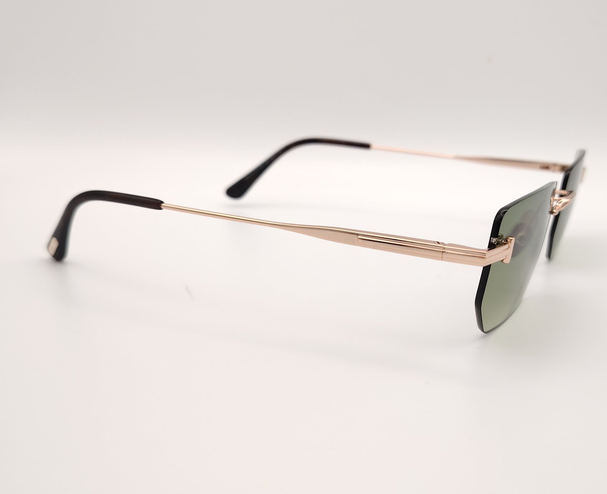 gafas de sol tom ford sin montura con lentes verdes y varillas metálicas doradas