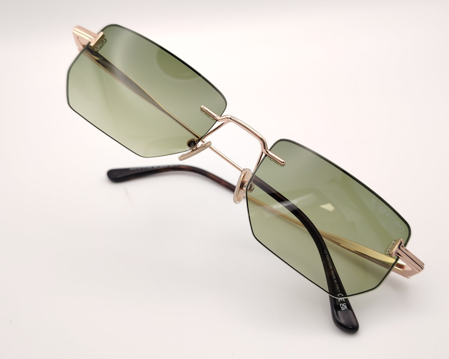 gafas de sol tom ford sin montura con lentes verdes y varillas metálicas doradas