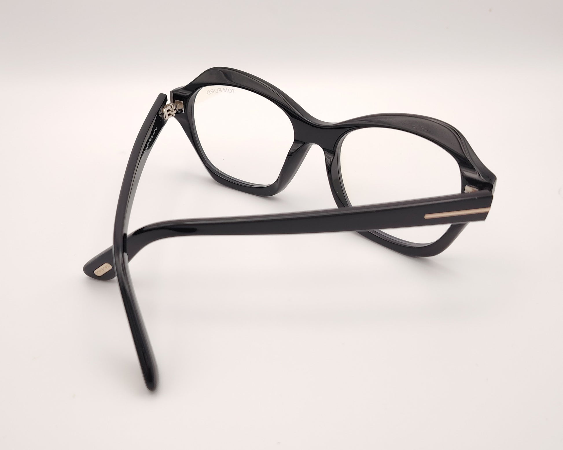 gafas tom ford negras de acetato con frontal geométrico redondeado y detalle metálico en las varillas