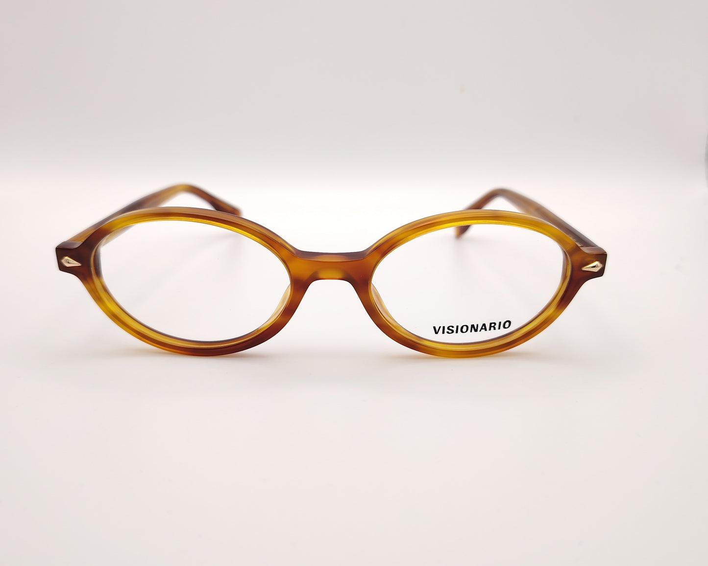 gafas de vista ovaladas en acetato ámbar con detalles metálicos dorados de la marca visionario