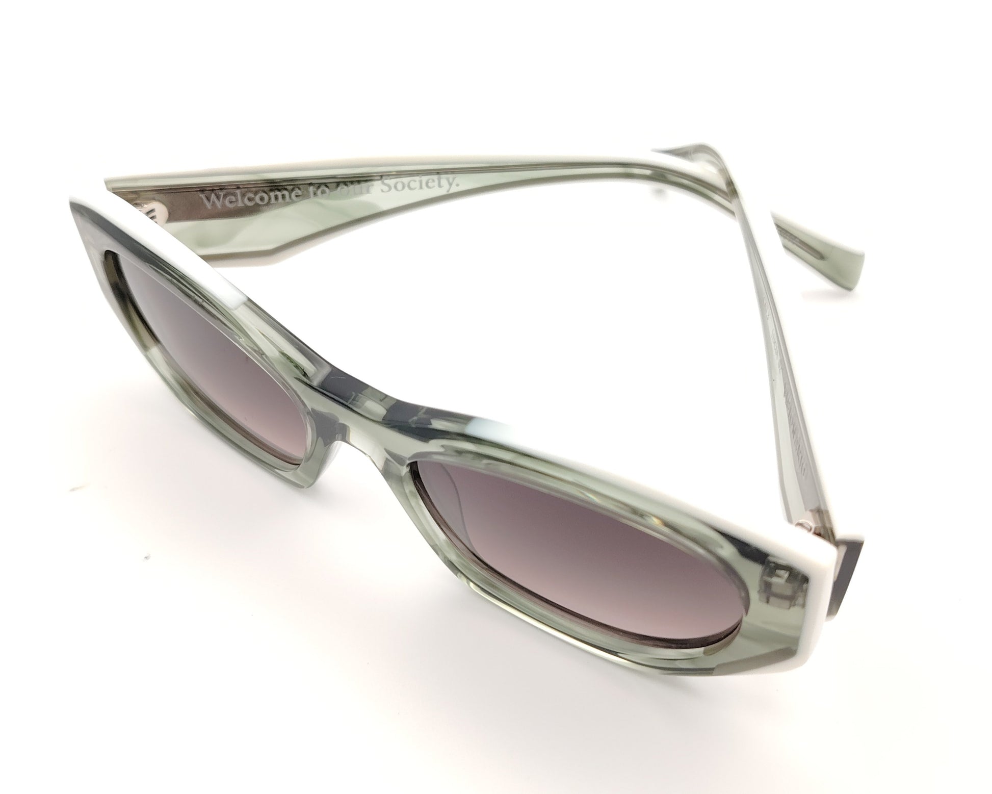 gafas de sol alargadas con montura translúcida verde gris y lentes rosadas ahumadas