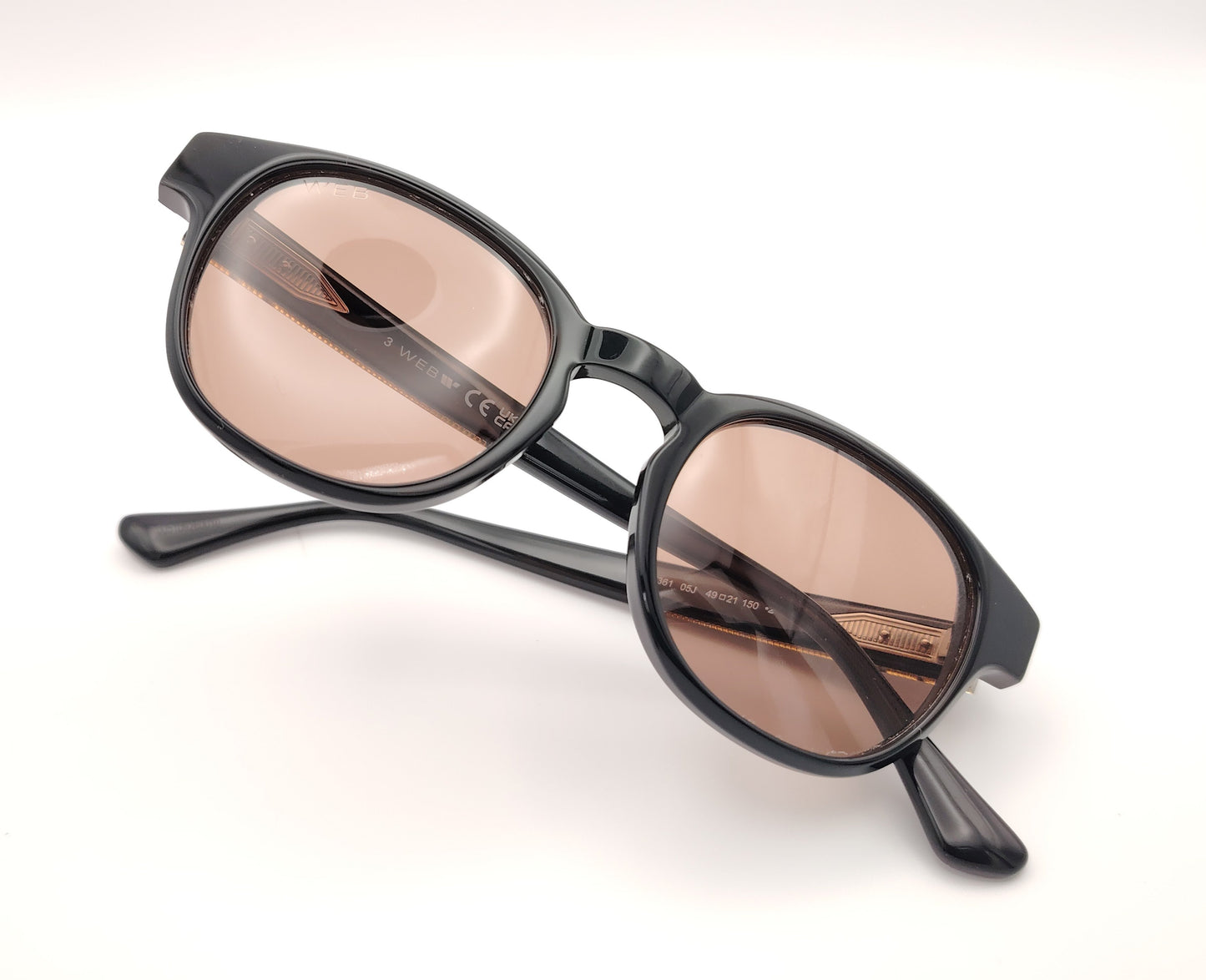 gafas de sol web eyewear con montura de acetato negro, puente metálico dorado y lentes marrones