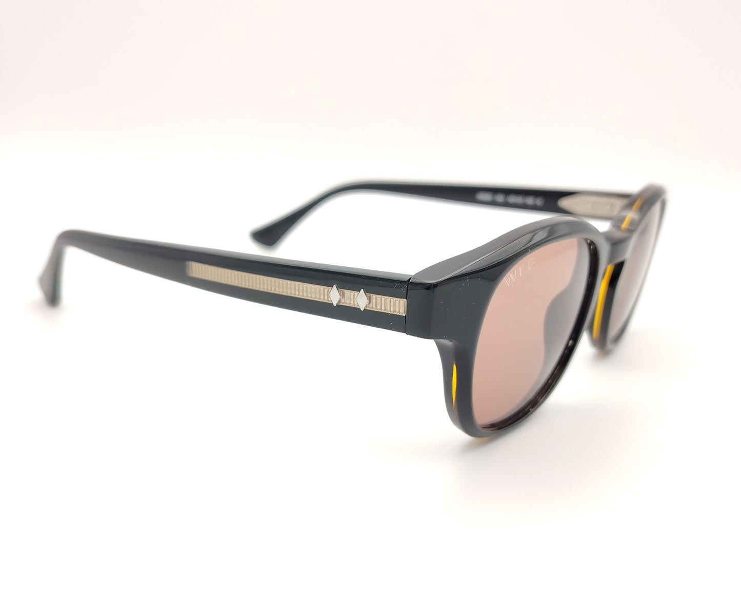 gafas de sol web eyewear con montura de acetato negro, puente metálico dorado y lentes marrones