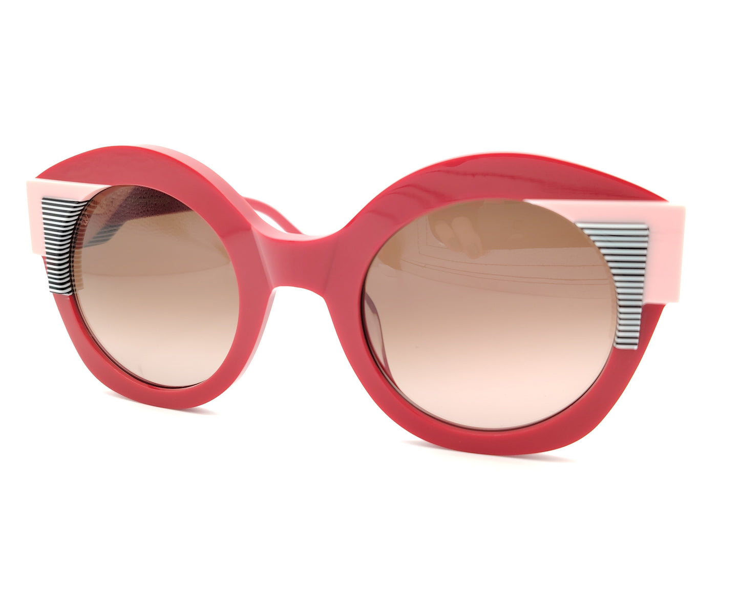 gafas de sol redondas rojas con detalles en rosa claro y líneas gráficas en blanco y negro