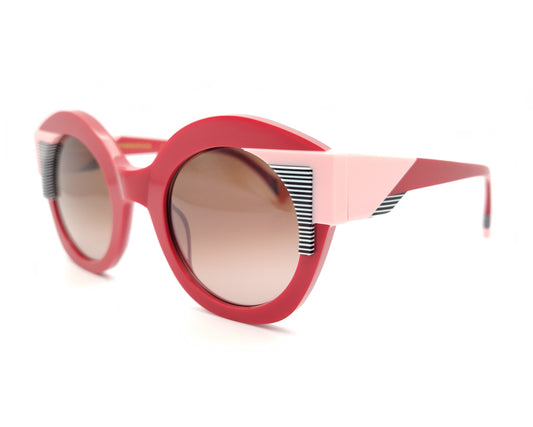 gafas de sol redondas rojas con detalles en rosa claro y líneas gráficas en blanco y negro