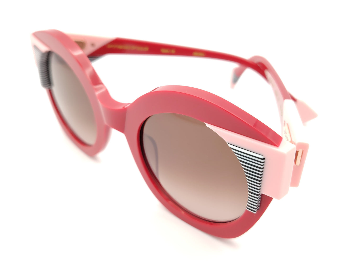 gafas de sol redondas rojas con detalles en rosa claro y líneas gráficas en blanco y negro