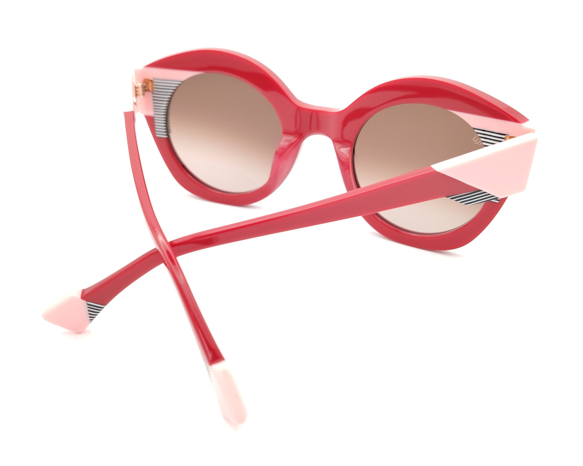 gafas de sol redondas rojas con detalles en rosa claro y líneas gráficas en blanco y negro