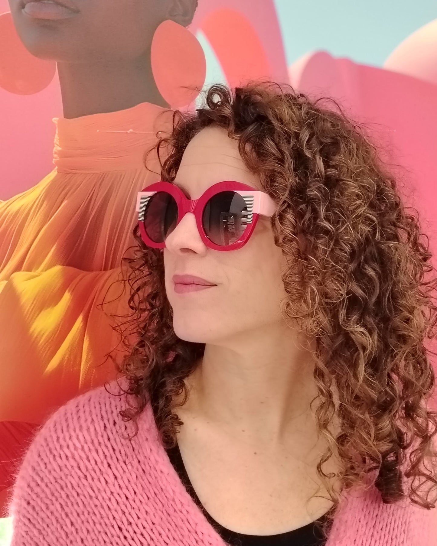 gafas de sol redondas rojas con detalles en rosa claro y líneas gráficas en blanco y negro