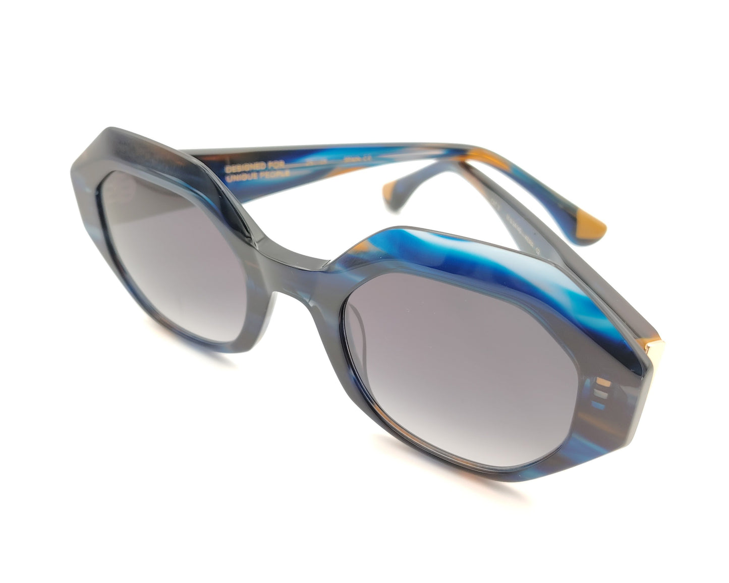 gafas de sol oversize geometricas en acetato azul marmoleado con lentes gris degradado y varillas en contraste miel