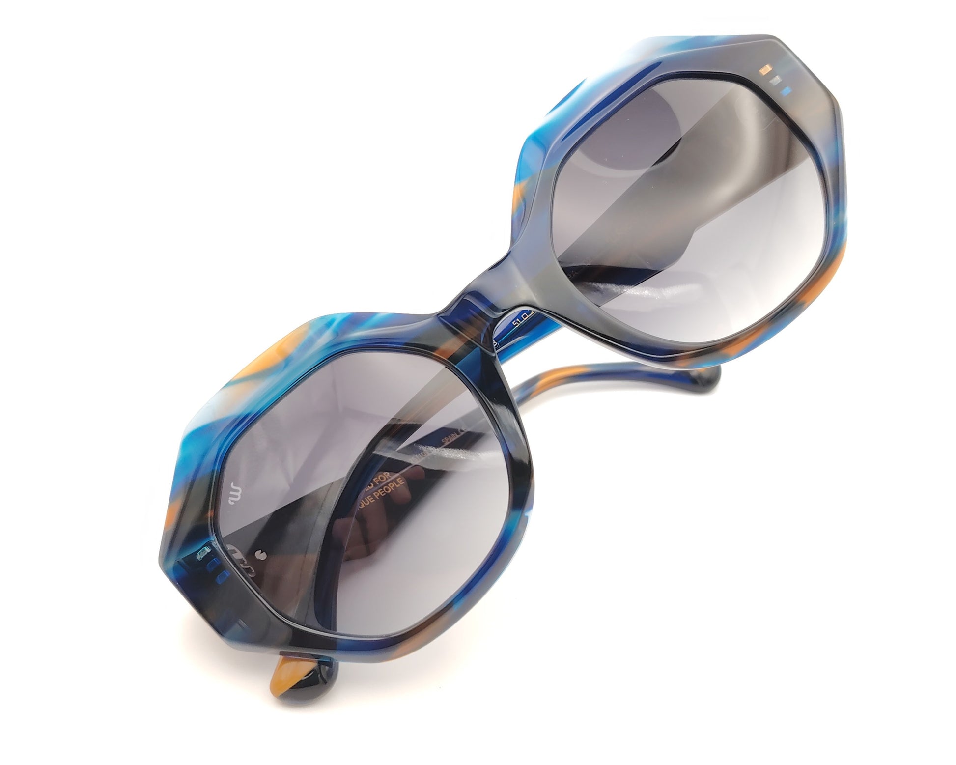 gafas de sol oversize geometricas en acetato azul marmoleado con lentes gris degradado y varillas en contraste miel