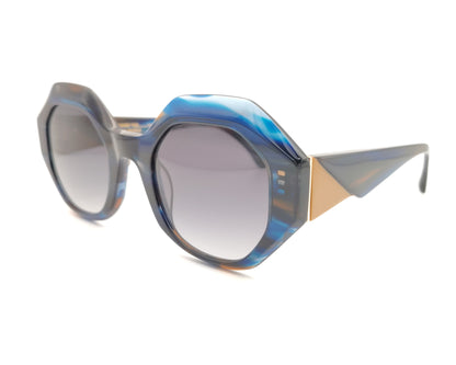 gafas de sol oversize geometricas en acetato azul marmoleado con lentes gris degradado y varillas en contraste miel