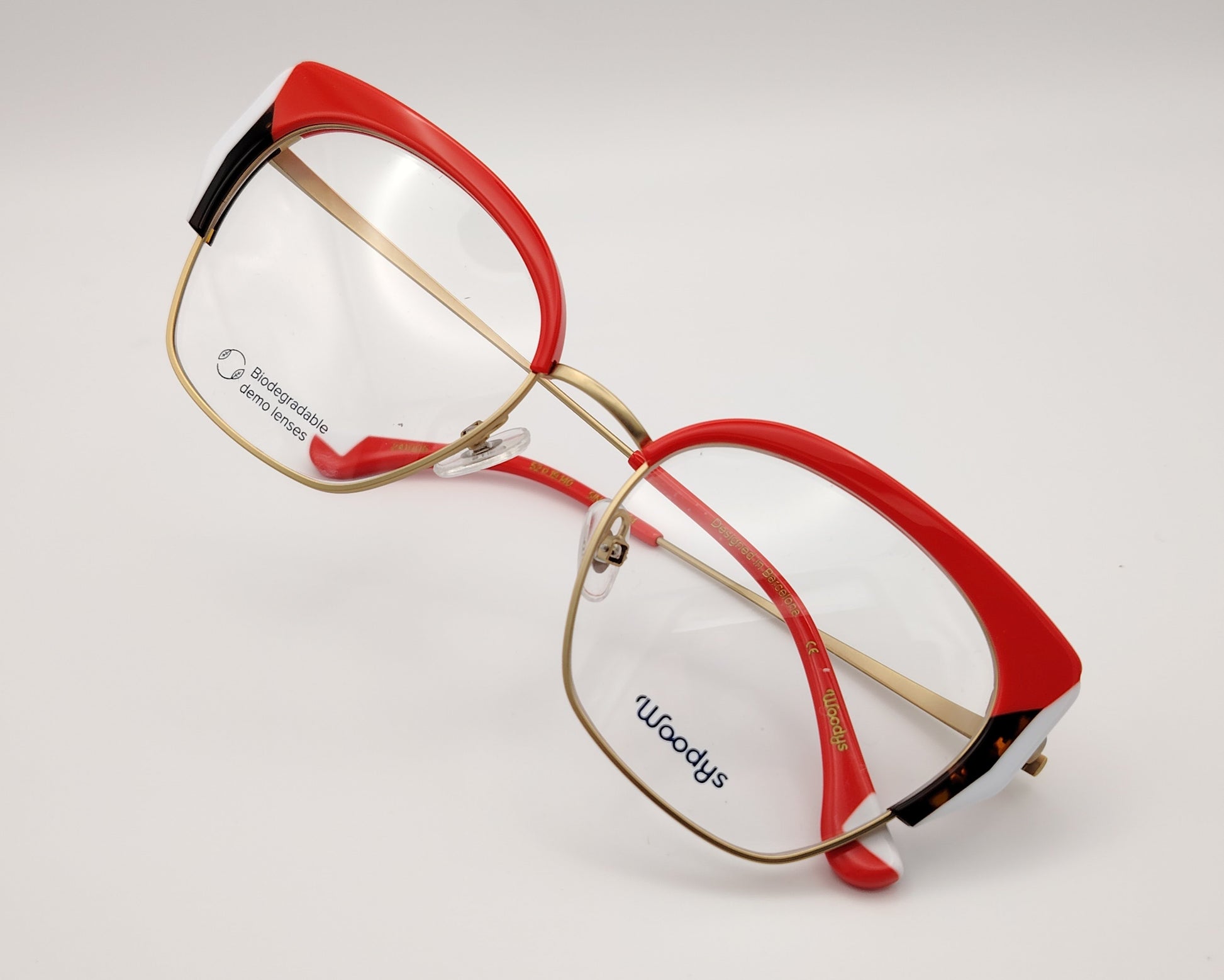 gafas graduadas woodys sinclair 04 con montura metálica dorada diseño cat eye con parte superior en acetato rojo detalles en blanco y habana en las esquinas varillas doradas con terminales en rojo estilo elegante y llamativo