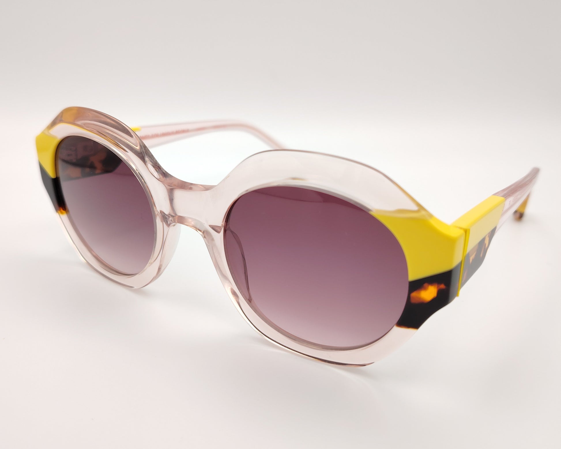 gafas de sol redondas transparentes con detalles en amarillo y carey en los extremos