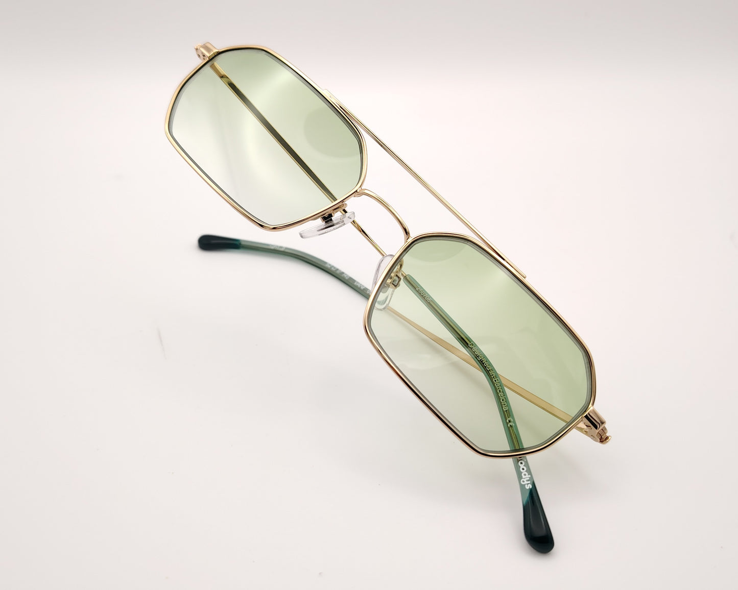gafas de sol metalicas doradas rectangulares con doble puente y lentes fotocromaticas verdes